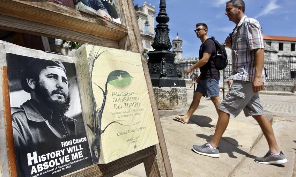 Un hombre camino junto a libros exhibidos dedicados al líder de la revolución cubana Fidel Castro con motivo de su 90 cumpleaños. EFE/Ernesto Mastrascusa