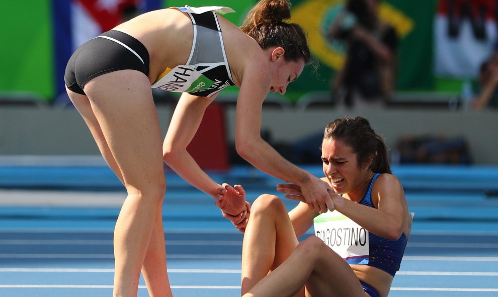 Nikki Hamblin de Nueva Zelanda deja de competir para ayudar a su rival Abbey D'Agostino de EE.UU, en Atletismo, 5000m femenino. REUTERS/ Kai Pfaffenbach