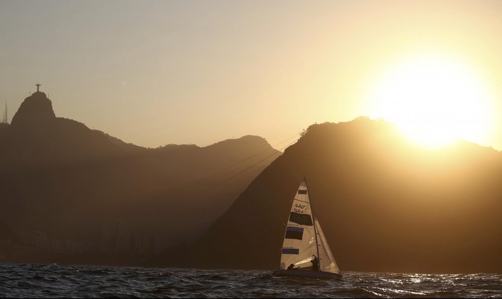 El atardecer perfila el skyline de la ciudad de Río de Janeiro, con el Cristo Redentor vigilando, sobre el cerro del Corcovado, las competiciones de Vela. REUTERS / Benoit Tessier