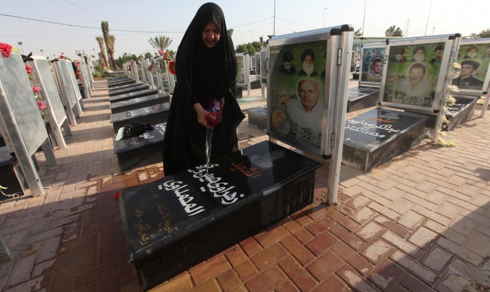 Una mujer lava la tumba de un familiar en el cementerio de Wadi al-Salam (el 'Valle de la Paz', en árabe), en Nayaf, al sur de Bagdad. REUTERS / Alaa Al-Marjani