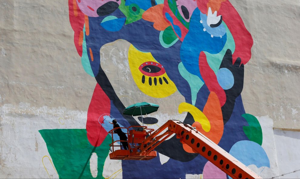 La artista brasileña Tarsila Schubert, trabaja en un mural sobre el empoderamiento de la mujer. El proyecto es parte del museo de arte abierto, cuyo objetivo es añadir color a la ciudad de Amman, en Jordania. REUTERS/Muhammad Hamed