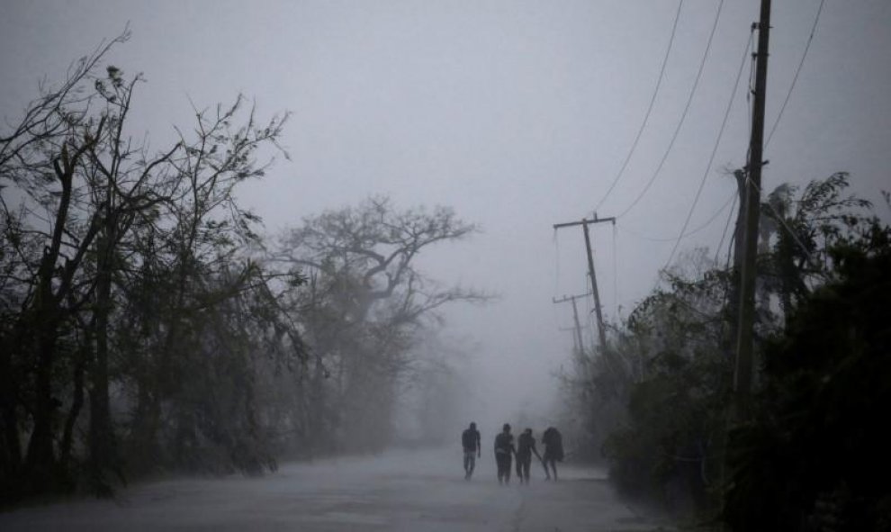 Un grupo de personas camina mientras cae una fuerte lluvia al paso del huracán Matthew en Les Cayes, Haiti. REUTERS/Andres Martinez Casares