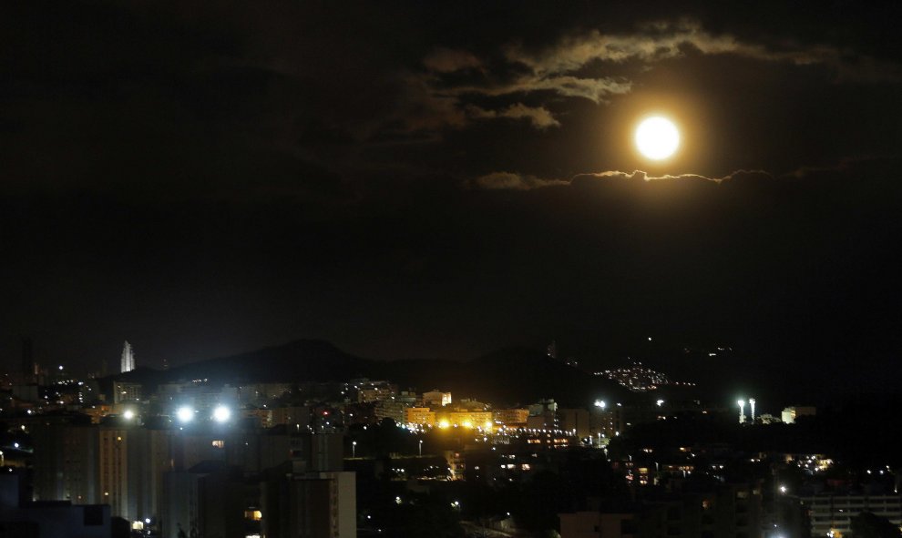 La luna sale tras las nubes por encima de la ciudad alicantina de Benidorm.EFE/Manuel Lorenzo
