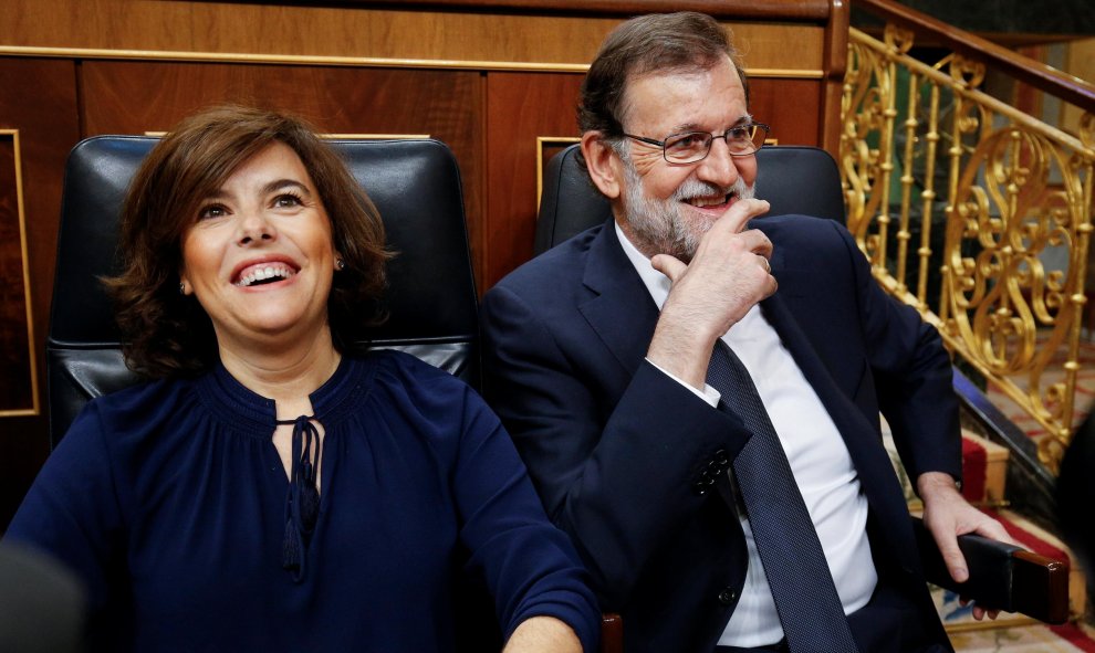 La vicepresidenta del Gobierno, Soraya Sáenz de Santamaría, y el presidente del Gobierno, Mariano Rajoy, se ríen antes de que comience el debate de moción de censura al Gobierno del PP. REUTERS/Juan Medina