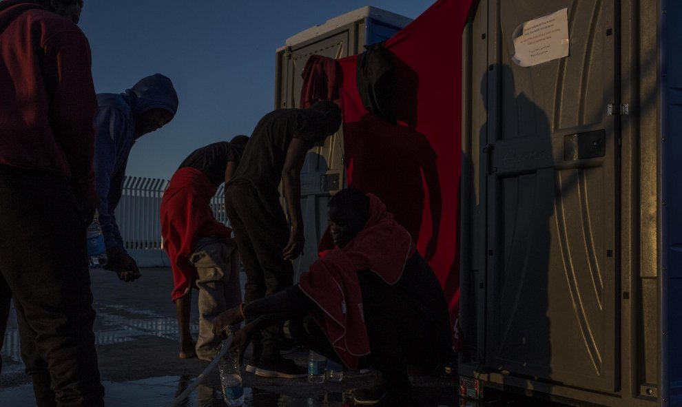 Un joven llena una botella de agua en el puerto de Algeciras. JAIRO VARGAS