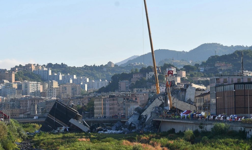 Una grúa trabaja en las labores de búsqueda de víctimas y retirada de los escombros del puente que el martes se desplomó en Génova (Italia). EFE/ Luca Zennaro