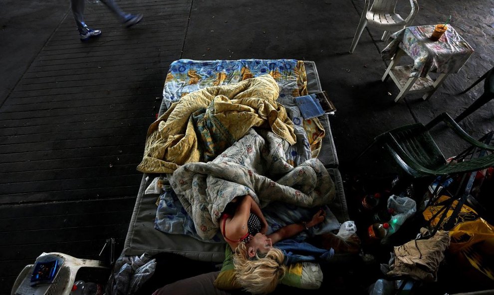 Marialena, una persona sin hogar de 42 años que padece SIDA y exdrogadicta, duerme bajo un puente en el centro de Atenas. / REUTERS - YANNIS BEHRAKIS