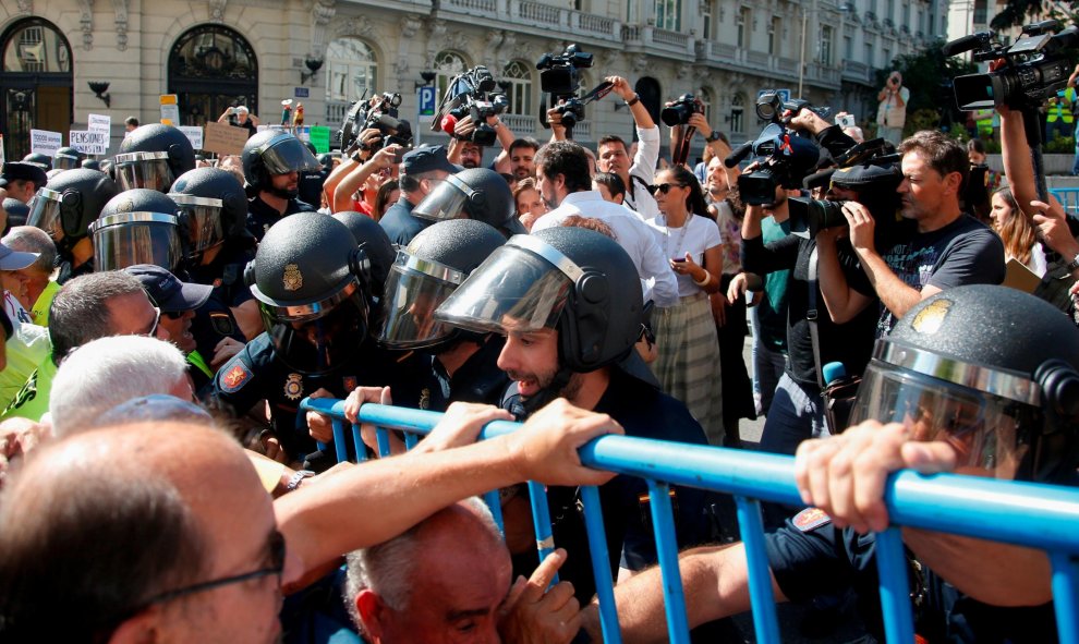 Grupos de pensionistas que se concentraron en el Congreso de los Diputados pidiendo mejoras en sus prestaciones intentan romper el cordón policial intentaba impedir su paso hasta la cámara. REUTERS/Stringer