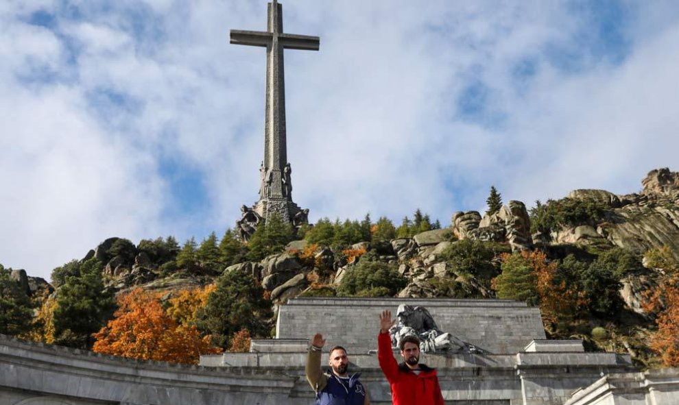 Dos jóvenes realizan el saludo fascista delante de la entrada principal del Valle de los Caídos. (SUSANA  VERA | REUTERS)