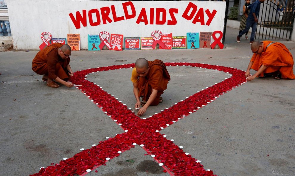 Los monjes budistas encienden velas durante una campaña de sensibilización sobre el VIH / SIDA con motivo del Día Mundial del SIDA en Calcuta.
