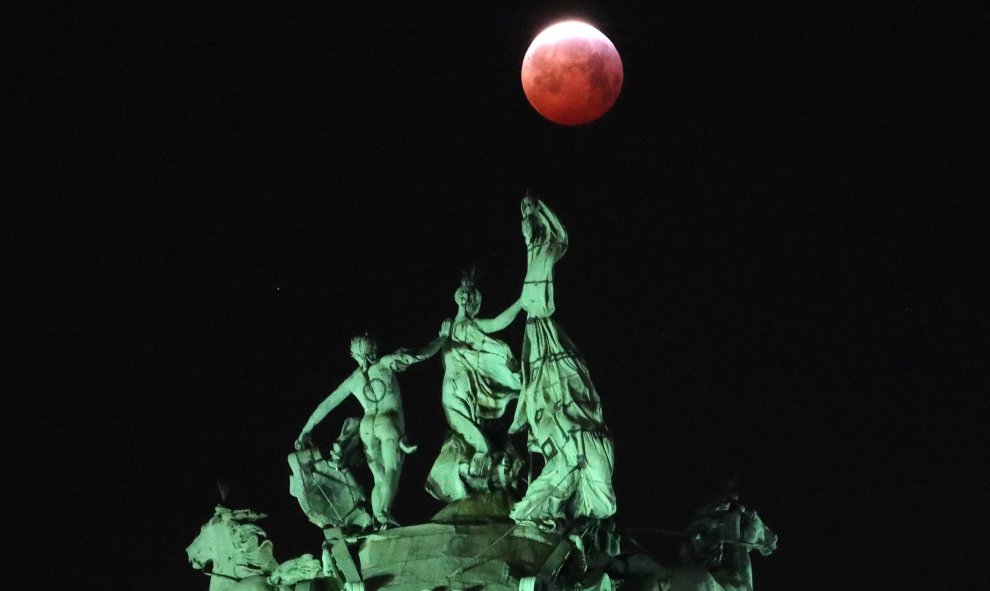 La luna vista a través de la cuádriga que corona el arco del Cinquantenaire en Bruselas, Bélgica. REUTERS/Yves Herman