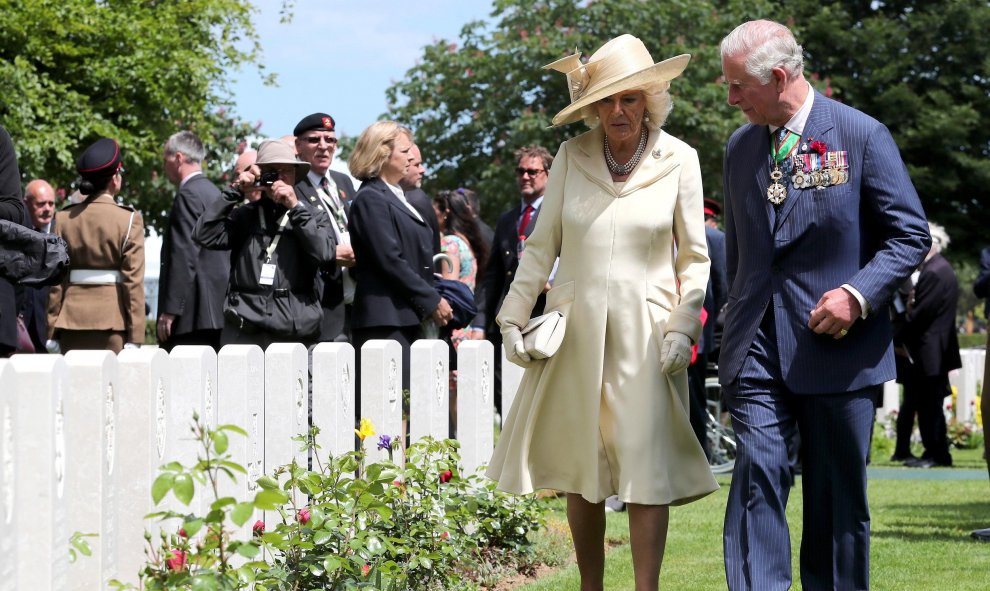 El príncipe Carlos de Inglaterra (d) y su mujer, la duquesa Camila de Cornualles (i), asisten a la ceremonia en el Cementerio de la Commonwealth | EFE