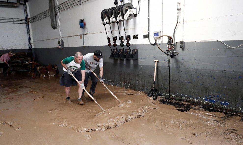 Dos de los vecinos de la localidad de Tafalla que han comenzado esta mañana las actividades de recuperación del municipio, tras las fuertes lluvias caídas desde primeras horas de la tarde de ayer. Las precipitaciones también han causado importantes daños