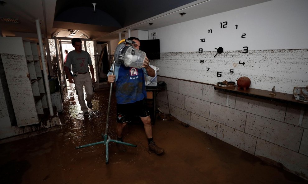 Vecinos de la localidad navarra de Tafalla limpian el interior de un local tras las fuertes lluvias caídas desde primeras horas de la tarde de ayer, que han causado importantes daños materiales en poblaciones como Olite, Pueyo, Pitillas o Beire.- EFE/Jesú