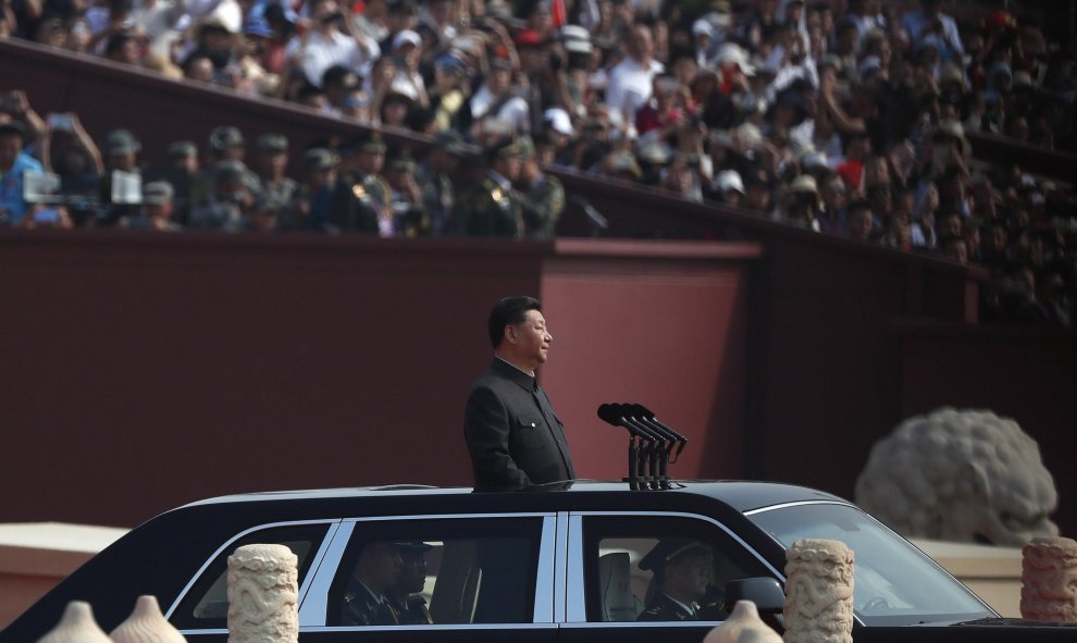 El presidente chino, Xi Jinping, viaja en una limusina abierta para revisar un desfile militar que conmemora el 70 aniversario de la fundación de la República Popular de China, en Beijing.  EFE / EPA / ROMAN PILIPEY