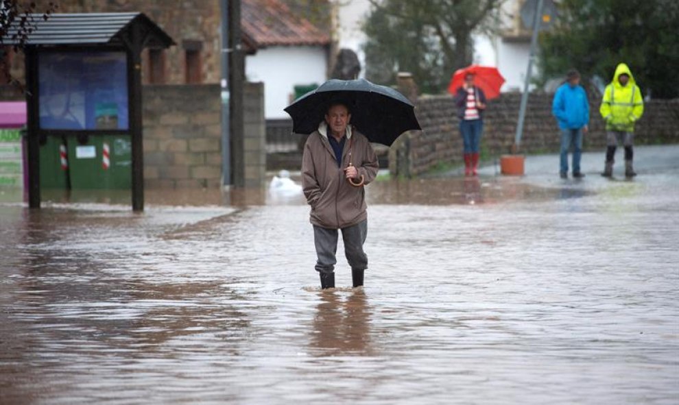 23/10/2019.- Un hombre camina por el agua que inunda Virgen de la Peña en Cantabria. EFE/Pedro Puente Hoyos