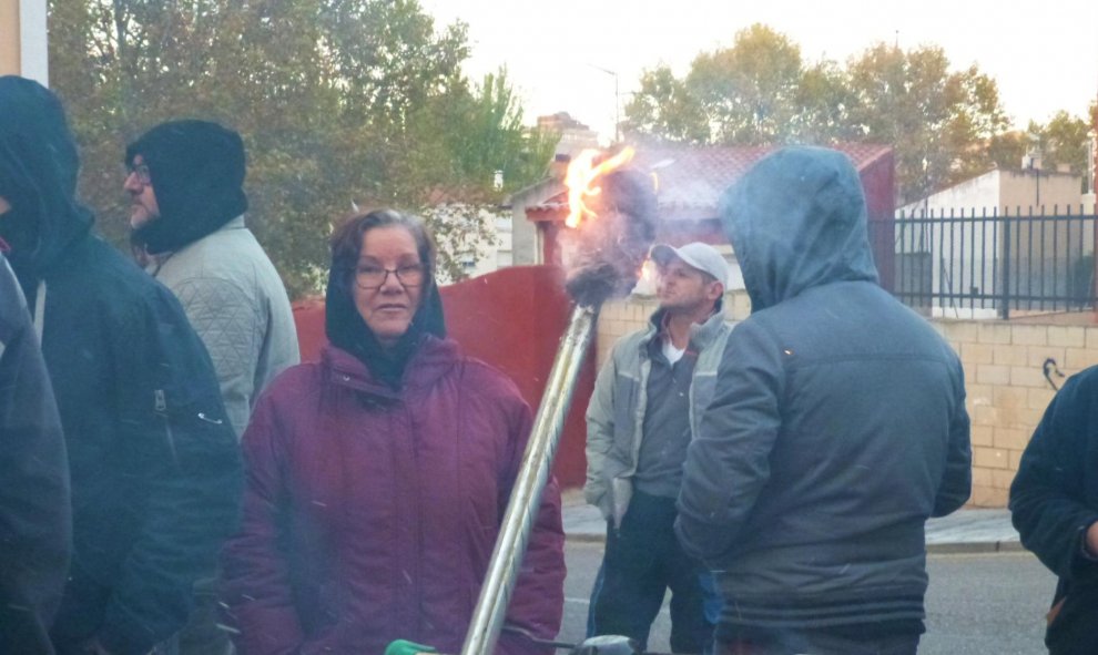 Una mujer calentándose en el fuego encendido durante la paralización del desahucio de Diego Catriel en Guadalajara. / María Duarte