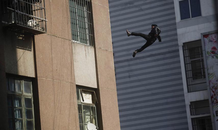 Un hombre cae desde lo alto de un edificio residencial en Loizhou. Según los medios locales el hombre, que no sobrevivió a la caída, resbaló mientras la gente trataba de convencerle de que abandonara la azotea. // REUTERS/STR