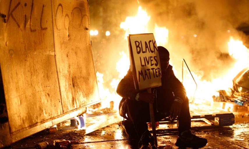 Un manifestante, durante las protestas por la muerte de un adolescente negro por los disparos de un policía en EEUU. // STEPHEN LAM (REUTERS)