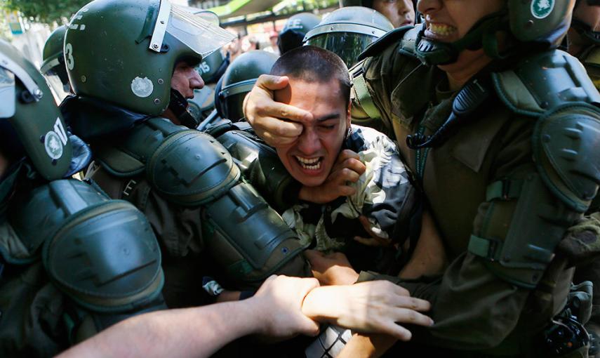 Un estudiante es detenido durante una manifestación cerca del Ministerio de Educación en Santiago de Chile contra el aumento en el precio de las tasas. /IVAN ALVARADO