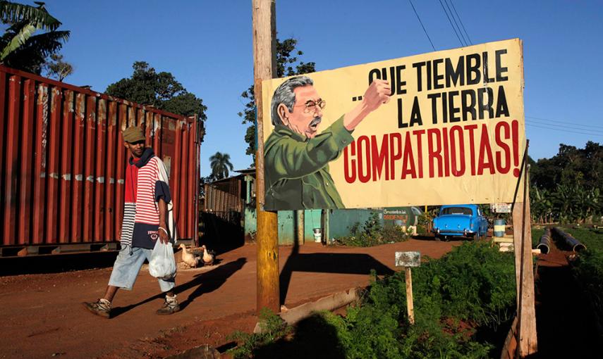 Un hombre camina cerca de un cartel con la imagen del presidente cubano Raúl Castro, en La Habana.- /REUTERS/STR