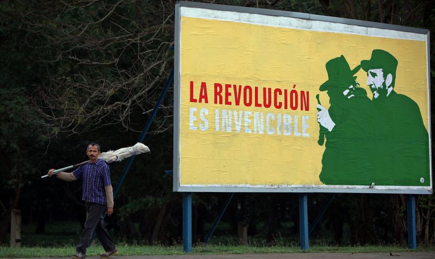 Un hombre camina junto a un cartel alusivo a la revolución cubana, en una calle de La Habana (Cuba). EFE/Alejandro Ernesto