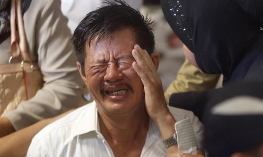 Familiares lloran al ser informados de que han encontrado cadáveres del avión desaparecido de AirAsia en Alta Mar tras días de espera en el aeropuerto de Juanda, en Surabaya. EFE