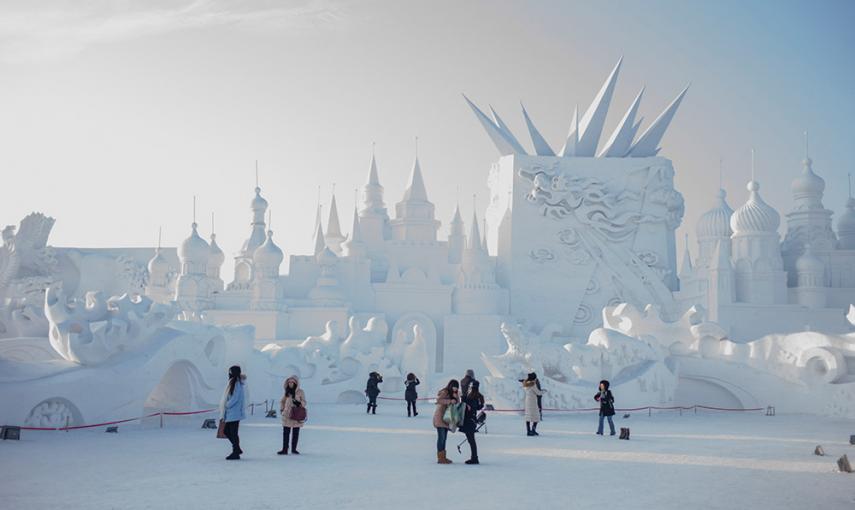Visitantes miran las esculturas de nieve durante el 16º Festival de Hielo y Nieve em Harbin (China). / FRED DUFOUR (AFP)