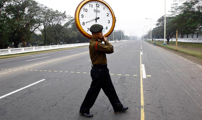 Un soldado indio cruza una carretera con un reloj de pared para controlar el tiempo del desfile durante un ensayo para el Día de la República en Kolkata. /RUPAK DE CHOWDHURI (REUTERS)