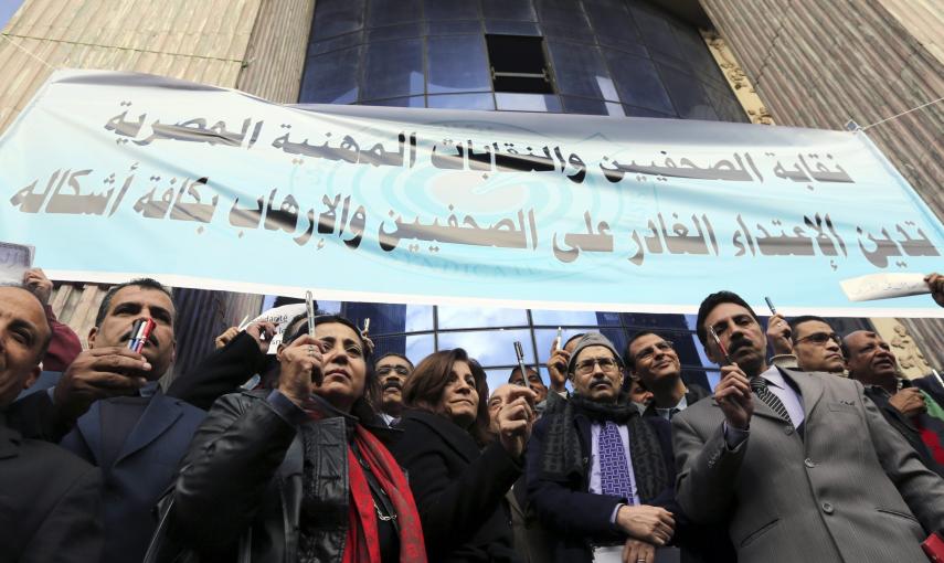 Journalists hold up pens as they participate in a silent protest against terrorism and in solidarity with the victims of a shooting by gunmen at the Paris offices of the satirical weekly newspaper Charlie Hebdo, in front of the Press Syndicate in Cairo, J