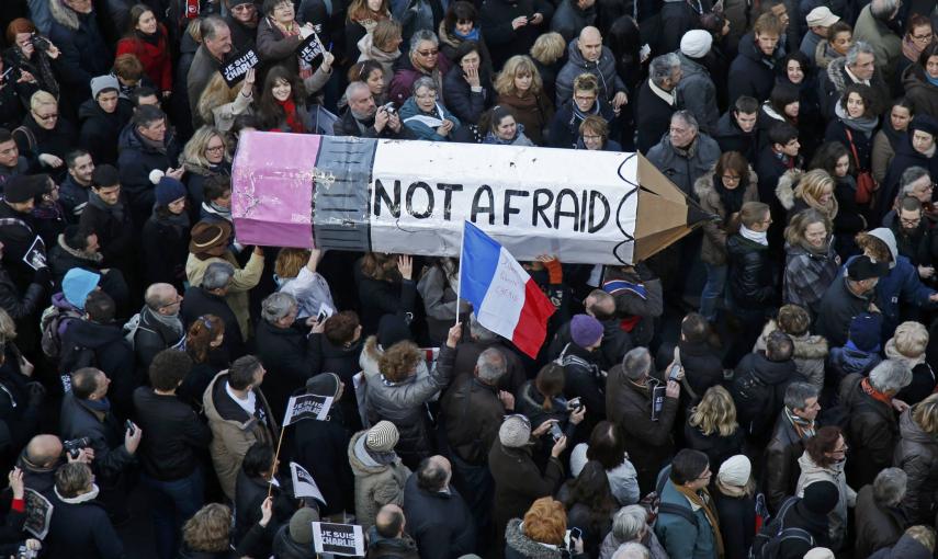Citizens carrying a giant cardboard pencil reading "Not Afraid" take part in a Hundreds of thousands of French citizens solidarity march (Marche Republicaine) in the streets of Paris January 11, 2015. French citizens will be joined by dozens of foreign le