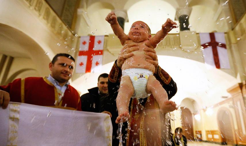 Un bebé es bautizado durante una ceremonia de bautismo en masa en el día de la Epifanía en Tbilisi. /DAVID MDZINARISHVILI (REUTERS)