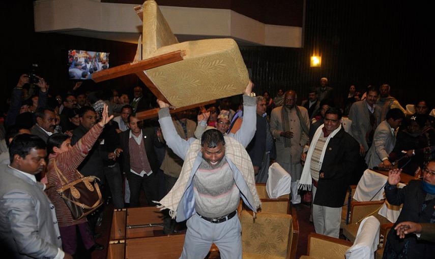 Un miembro de la oposición en la asamblea constituyente de Nepal lanza una silla. /BIKASH DWARE (REUTERS)