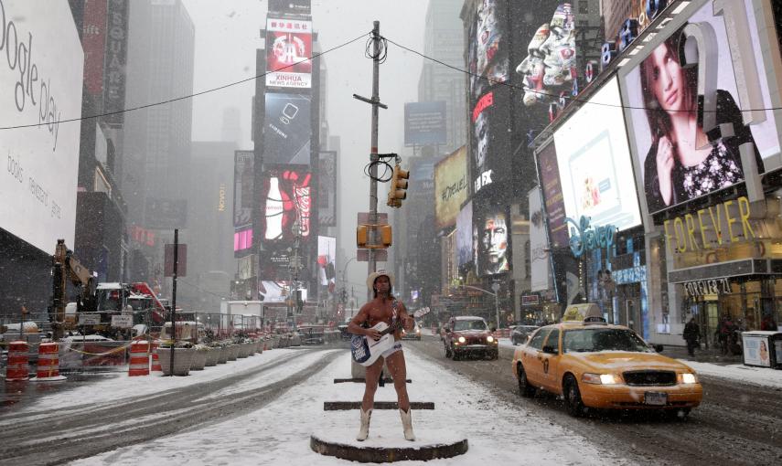 El artista callejero Robert John Burck, conocido como 'El Vaquero Desnudo', canta en Times Square. EFE/JASON SZENES