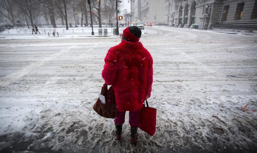 Una mujer cruza una calle cubierta de nieve. EFE/ANDREW KELLY