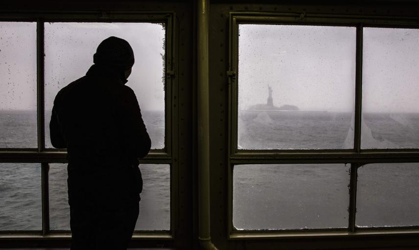 Un hombre observa la Estatua de la Libertad. REUTERS/Elizabeth Shafiroff