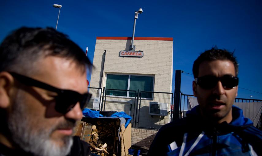 Dos trabajadores de Coca-Cola conversan en el campamento de protesta a las puertas de planta, que lleva un año cerrada. -JAIRO VARGAS