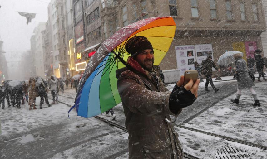 Un vendedor ambulante de paragüas se hace una selfie mientras nieva en la principal calle peatonal en el centro de Estambul./REUTERS-Murad Sezer