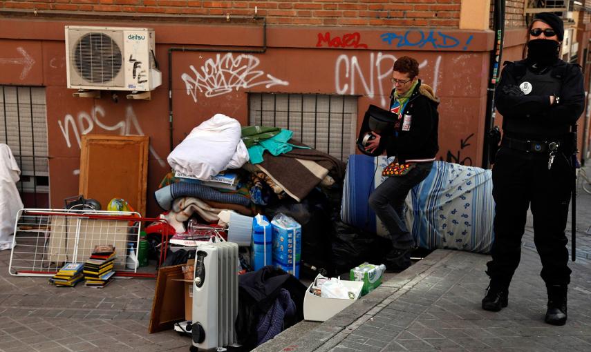 Un activista antidesahucios ayuda a trasladar las pertenencias de una familia desalojada en Madrid. /SUSANA VERA (REUTERS)