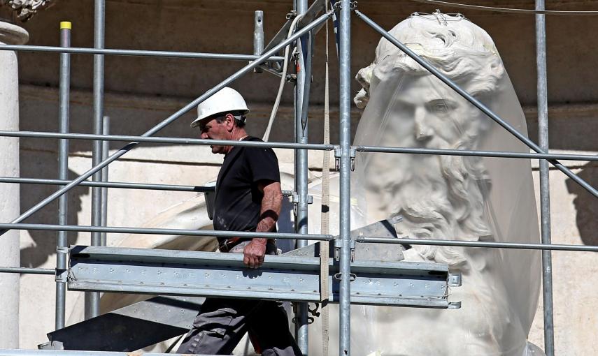 Un trabajador retira los andamios que cubren la popular Fontana di Trevi, en Roma, durante los trabajos de restauración. EFE/Alessandro Di Meo