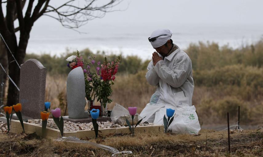 Norio Kimura reza por su familia frente a un monumento que hizo por su familia a la que perdió, el 11 de marzo de 2011 en el tsunami, cerca de Okuma al lado de TEPCO./ REUTERS-Toru Hanai