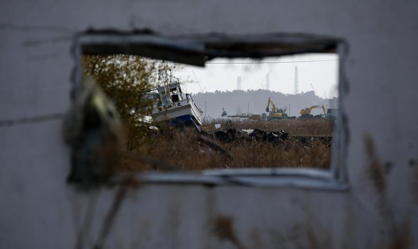 Un barco pesquero arrastrado por el tsunami del 11 de marzo de 2011, a través de la ventana de una casa abandonada en Namie./ REUTERS-Toru Hanai
