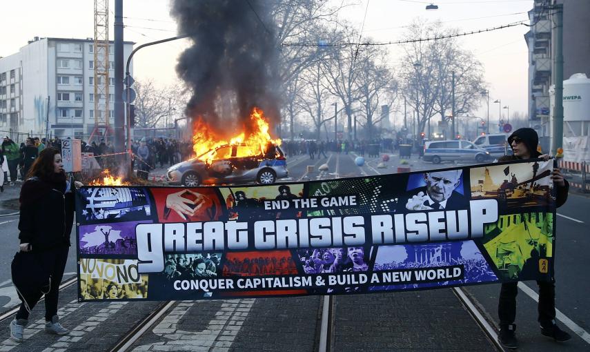 Los manifestantes despliegan una pancarta contra las políticas capitalistas y muestran que "el juego ha terminado"./ REUTERS