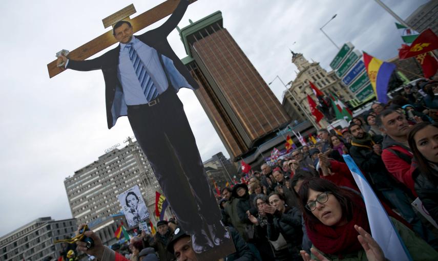 Un manifestante sostiene una imagen del presidente del Gobierno, Mariano Rajoy,  crucificado, durante la concentración de las Marchas de la Dignidad en la madrileña Plaza de Colón. REUTERS/Sergio Perez