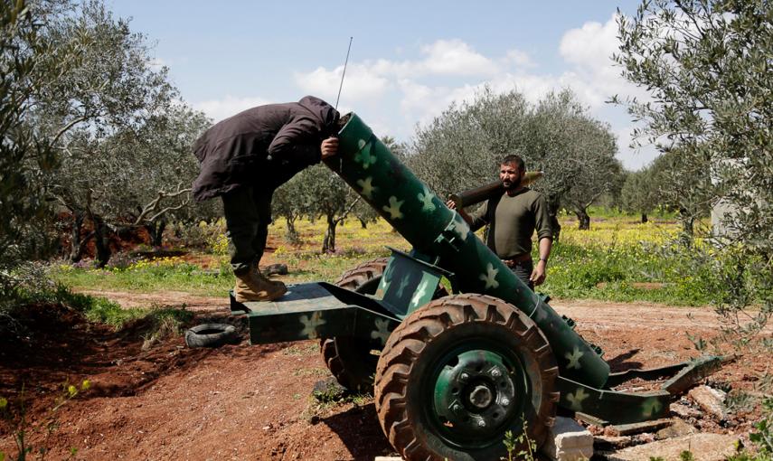Un rebelde sirio mira dentro de un cañón en el norte de Siria. /KHALIL ASHAWI (REUTERS)