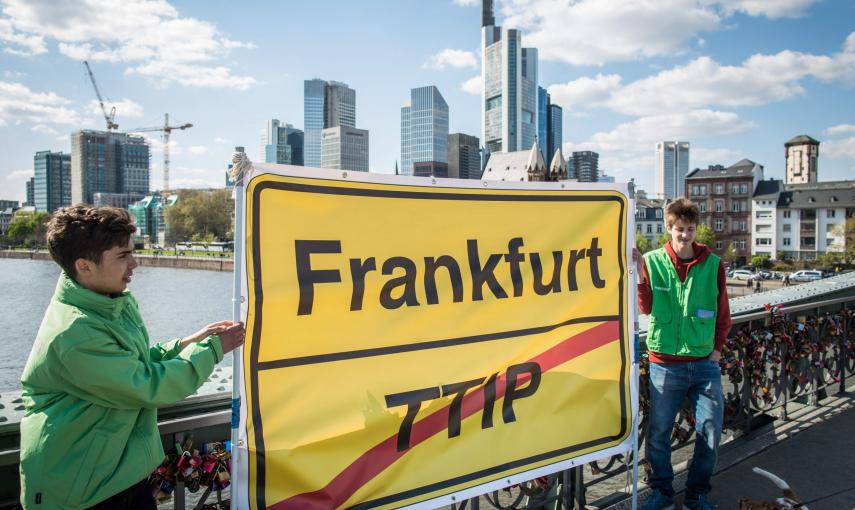 Dos activistas de Greenpeace con un pancarta contra el TTPI, con el 'skyline' de Fráncfort, la capital financiera de la UE. EFE/EPA/FRANK RUMPENHORST