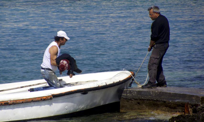 Un hombre traslada el cuerpo de un niño muerto en la costa sureste de la isla de Rodas en Grecia. Decenas de inmigrantes han fallecido en la última semana tratando de llegar a las costas europeas. / ARGIRIS MANTIKOS (REUTERS)