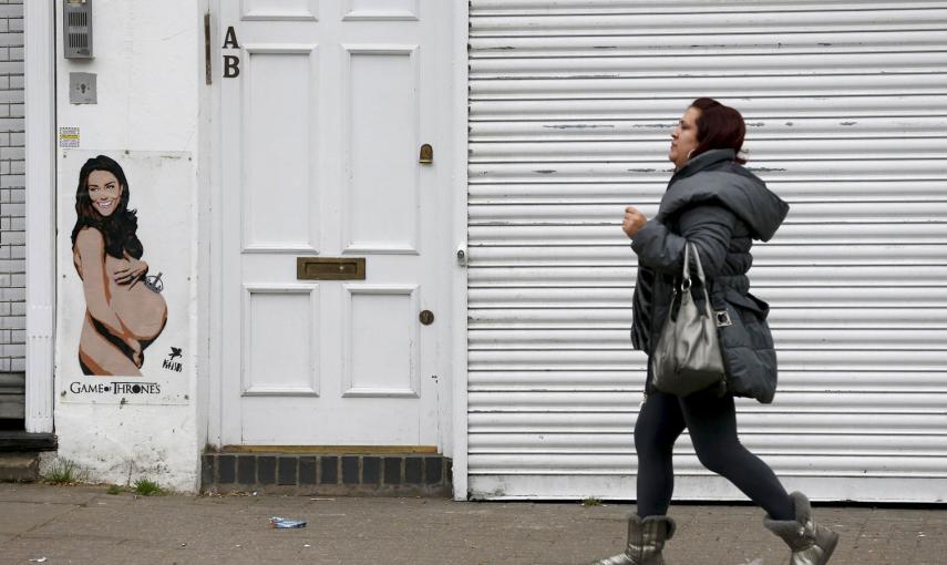 Una mujer pasea ante un graffiti que representa a la duquesa de Cambridge, en el norte de londres. /CATHAL MCNAUGHTON (REUTERS)