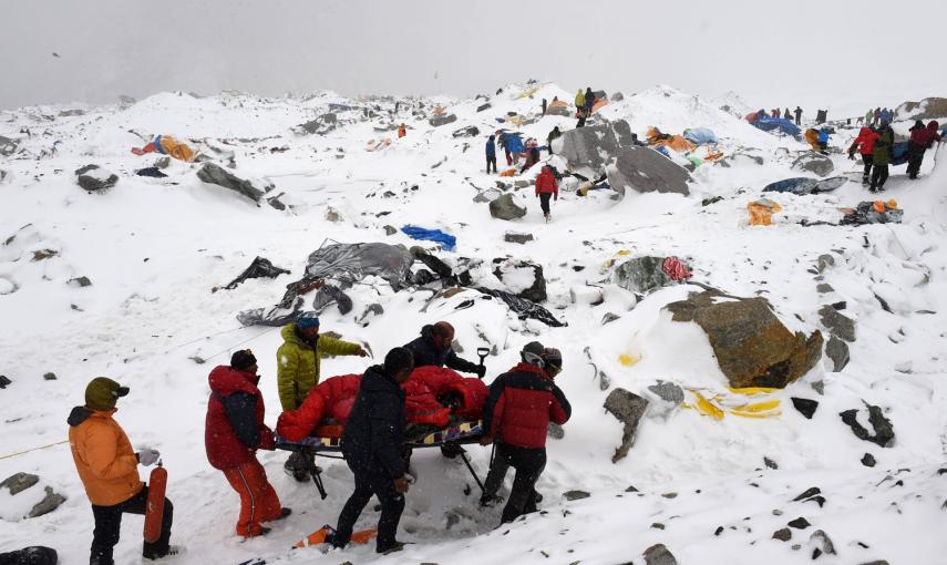 Los equipos de rescate usan una camilla improvisada para llevar a una persona herida después de la avalancha provocada el sábado por el terremoto, arrasando el campo base del Everest.- AFP PHOTO / Roberto SCHMIDT