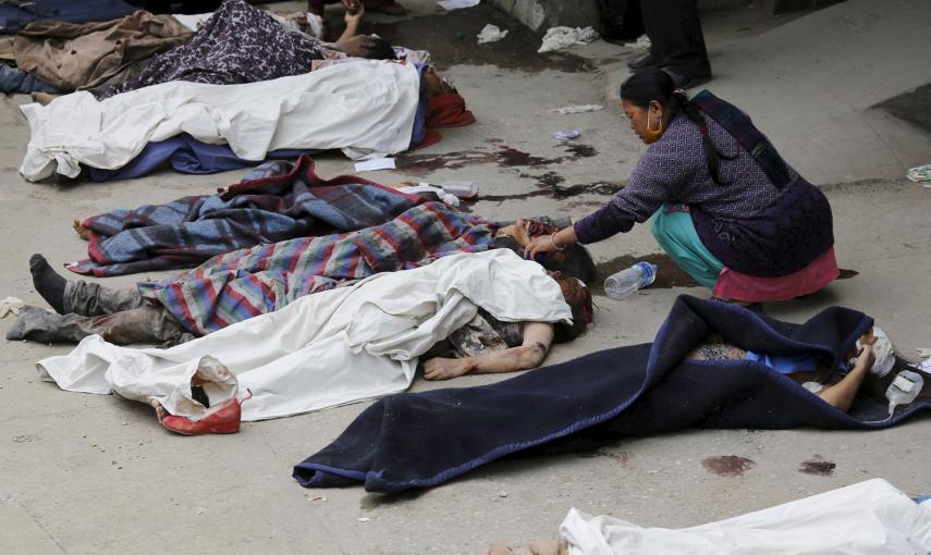 Una mujer trata de identificar un cuerpo fuera del hospital después del terremoto, en Katmandú, Nepal.- REUTERS / Adnan Abidi